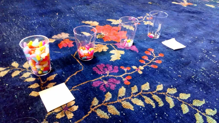 three plastic cups with jelly beans on a carpet